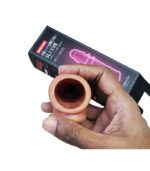 Hand holding the flexible opening of a brown reusable silicone sleeve